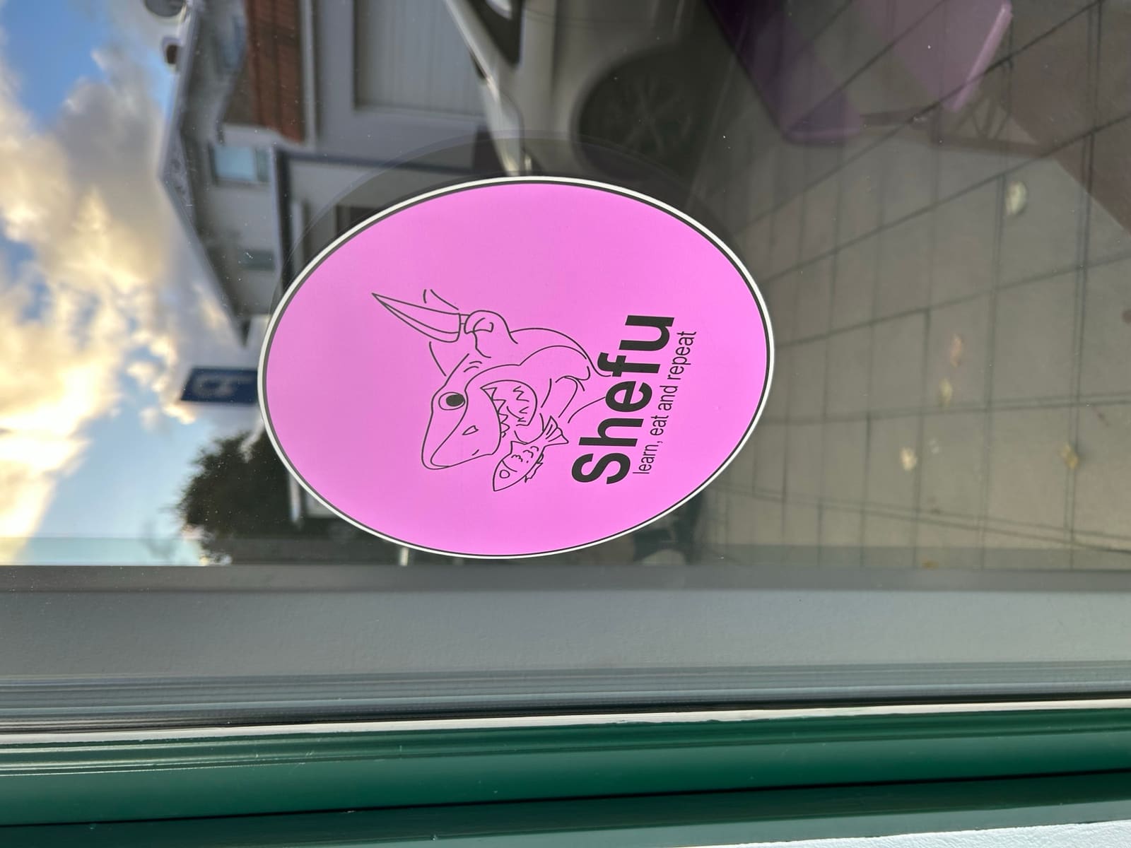 Eingangstür von Shefu in der Anastasiastraße mit dem Hai-Logo im Fenster